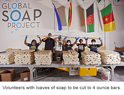 volunteers with loaves of soap to be cut into 4 ounce bars dispenser amenities