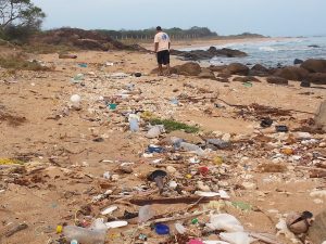 Man walks along plastic beach