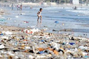 Child walks along trash filled beach in Sri Lanka