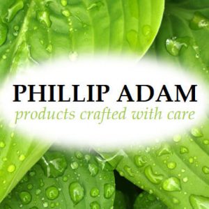 Phillip Adam products crafted with care background of leaves covered with dew dispenser amenities
