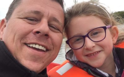 man and little girl in life jacket smiling at camera dispenser amenities