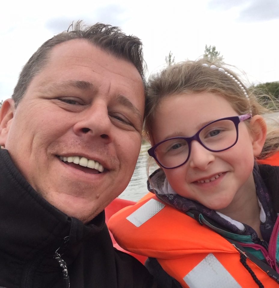 Man and little girl in life jacket smiling at camera dispenser amenities