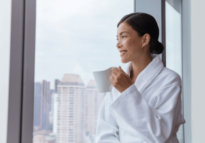 Dispenser Amenities Woman Hotel Guest Relaxing Near Window In Hotel Room SOLera Dispensers Blog SOLera dispenser image
